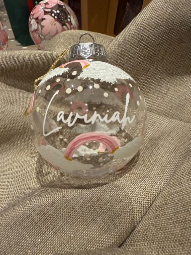 Clear glass ornament with white writing reading "Caviniah" and decorative patterns.